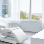 ¿Cuándo se puede conducir después de un injerto capilar? Sala de valoración premium en Clínica Frontela Huelva con llaves de coche y gafas de sol sobre encimera blanca para el postoperatorio del trasplante capilar