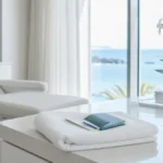 ¿Se puede viajar en avión después de un injerto capilar? Sala de valoración premium en Clínica Frontela Huelva con funda de pasaporte sobre toalla blanca para planificar el vuelo de regreso tras el trasplante capilar